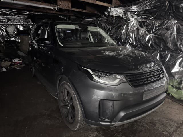 police officers examining vehicles at a chop shop in Romford