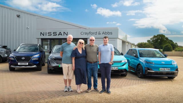 Such family posing beside their Nissan Leaf, Ariya, Micra and X‑Trail e‑Power at Crayford & Abbs