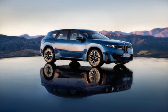 BMW electric vehicle on showroom floor with branding highlighting two‑millionth delivery milestone